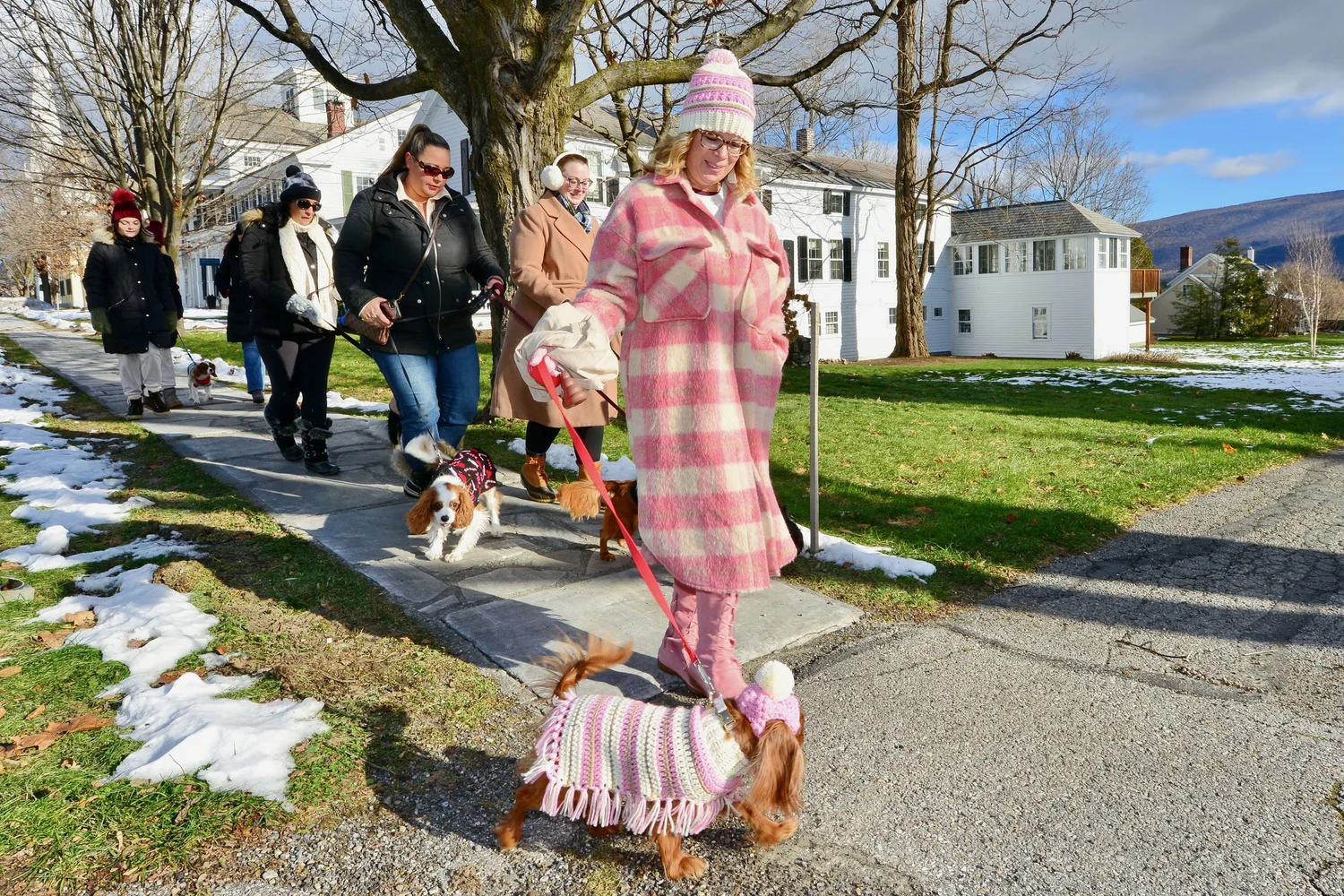 a person in a garment walking a dog on a leash