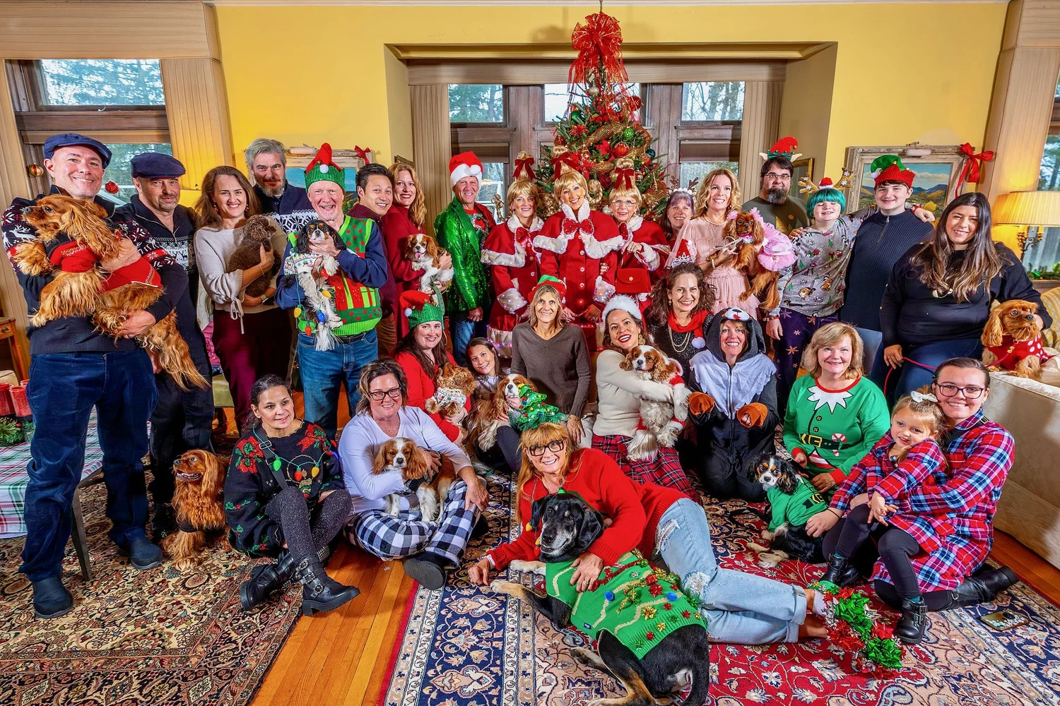 a group of people posing for a photo in front of a christmas tree
