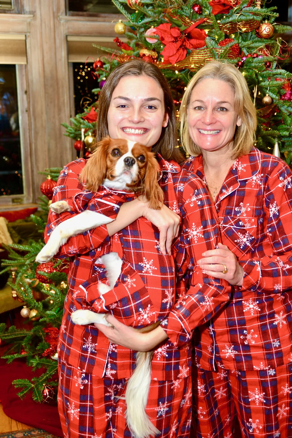 a couple of women holding a dog